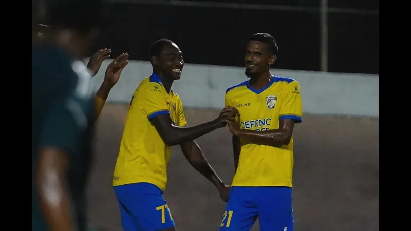 Cầu thủ của Defence Force vượt qua phòng ngự của Prisin Service trong trận đấu bóng đá